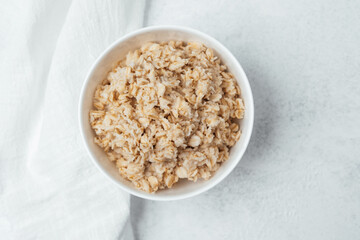 Healthy oatmeal served in a white bowl for breakfast or snack preparation