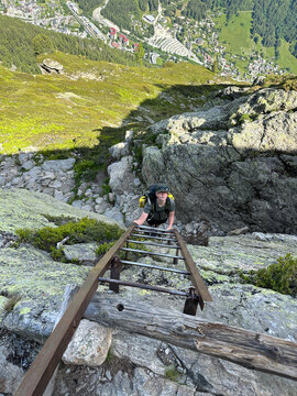 teen boy descending ladders on the TMB, Alps