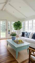 Fototapeta premium Light and airy sunroom with a light teal coffee table, white sofa, and potted tree