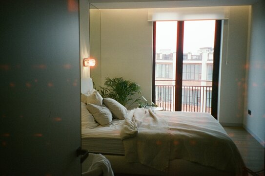 Cozy bedroom setting with disheveled bed and natural light