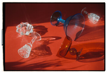 Colorful glassware reflects light on vibrant orange surface