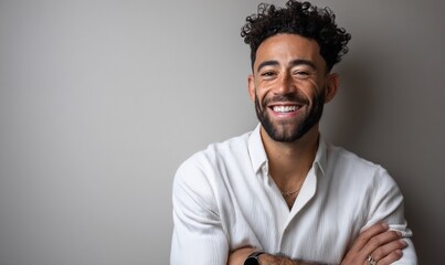 Obraz premium Portrait of a smiling man with arms crossed against a neutral background, suitable for use in a business or personal branding context