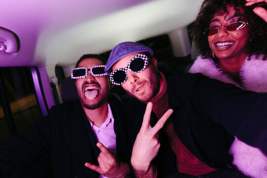 Selfportrait of three friends going to a party inside a car