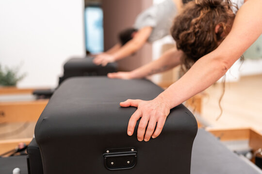 People doing pilates exercises on reformers in a gym