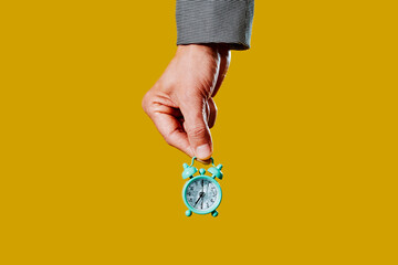 man holds a toy alarm clock with broken glass