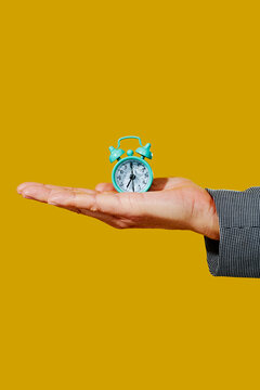 man has an alarm clock with broken glass on his hand