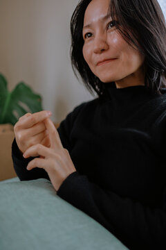 A warm moment of a woman holding back laughter indoors.
