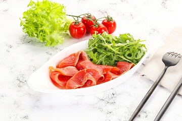 Sliced salmon with fresh arugula