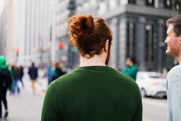 Anonymous ginger man looks to friend while walking in Chicago