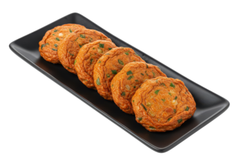 Fried fish cakes neatly aligned on a sleek black platter against a dark background