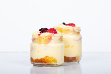 Delicious creamy dessert in glass jars topped with fresh strawberries, blackberries, and raspberries, perfect for sweet moments, homemade treats, and dessert lovers