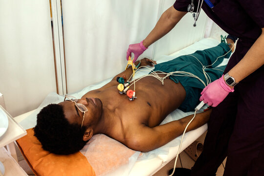 A cardiologist prepares the cardiograph sensors for an ECG procedure.