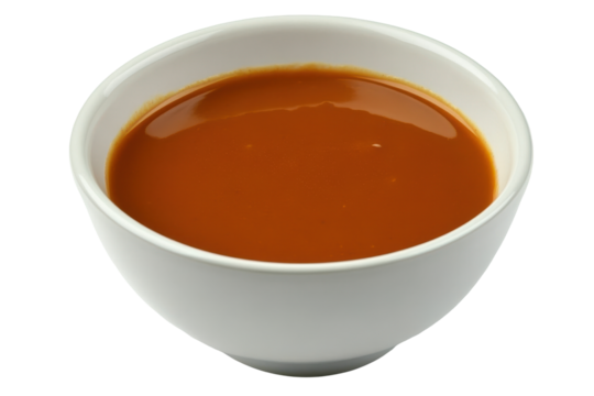 Smooth tomato soup in a white bowl gleams under the studio light