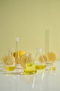 Glass Lab Bottles with Lemon Yellow Liquid and Halved Lemons