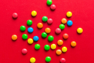 Mixed collection of colorful candy, on colored background. Flat lay, top view. frame of colorful chocolate coated candy