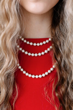 Multiple strands of pearls create an elegant look against a red dress
