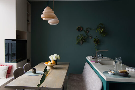 Modern kitchen and dining area with green walls and stylish decor