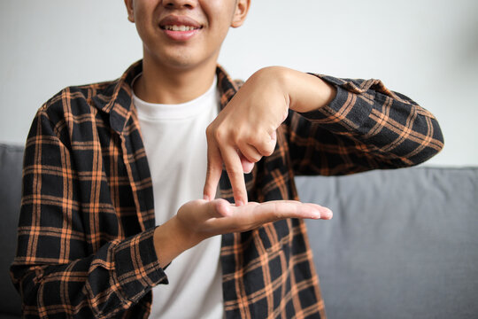 Cropped man smiling and showing gesture meaning stand on sign language