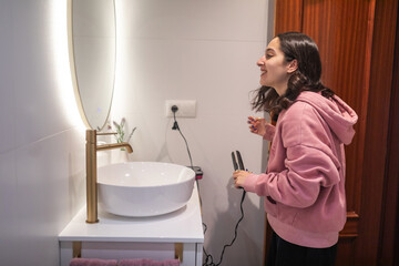 young woman fixing her hair in the bathroom