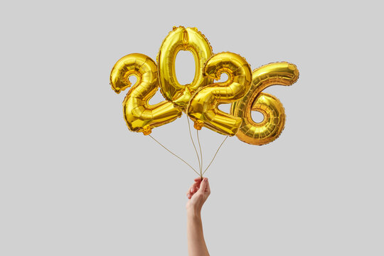 Woman holding 2026 balloons