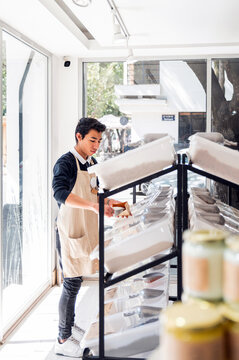 Employee Restocking Shelves in a Bright Bulk Food Store