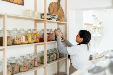 Organizing spices in glass jars on wooden shelves in a kitchen