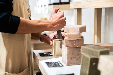 Artisan slicing handmade soap bars in a craft workshop