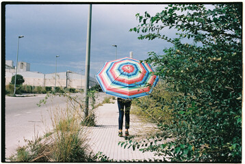 man carries an open beach umbrella, 35mm