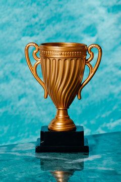 fake gold cup trophy on a marble surface