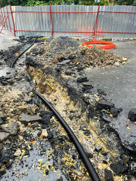 Urban Road Excavation Site With Exposed Cable and Equipment