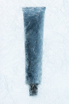 a tube of cream behind a thin crust of ice