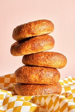 Stack of freshly baked bagels on a checkered tablecloth. 