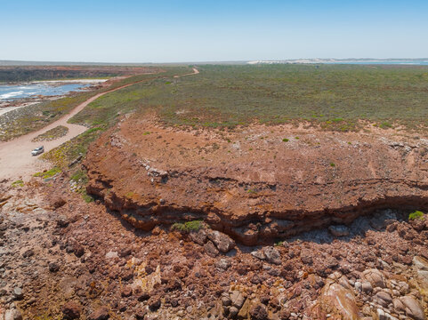 Large undercut coastal headland of red rock