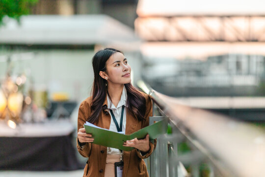 Female Architect Reviewing Plans for Eco-Friendly Building. - Powered by Adobe