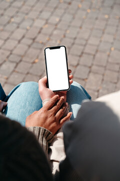 Couple holding empty mobile phone with white screen