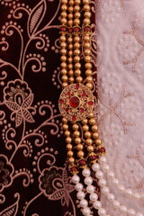 Elegant Gold and Pearl Necklace With Intricate Red Gemstone Pendant Design