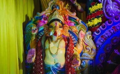 Vivid statue of Lord Ganesh in traditional attire, decorated with vibrant colors and intricate...