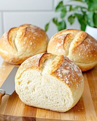 Fototapeta premium Two freshly baked bread rolls on a wooden cutting board ready to be served for a delicious meal