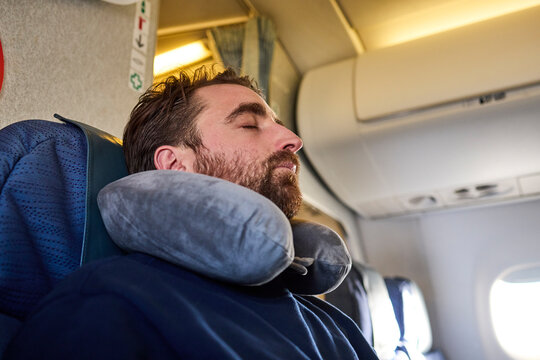 Man wearing neck pillow sleeping