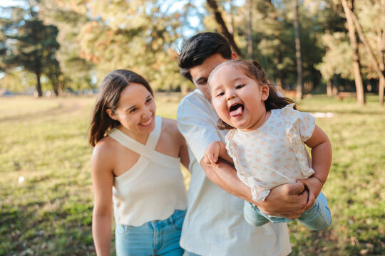 Playful young parents lifting their daughter