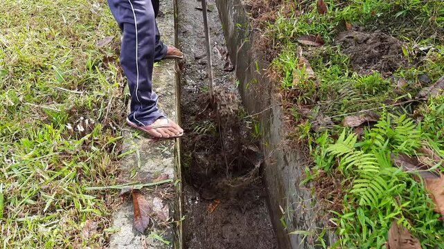 Village cleaners in Indonesia Cleaning Water Channels Using Hoes