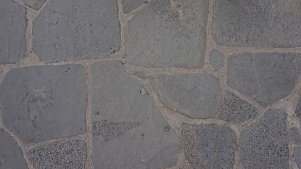 A high-quality stock image featuring a detailed view of a rustic stone pavement with textured surfaces and gaps filled with mortar, perfect for architectural and landscaping visuals.