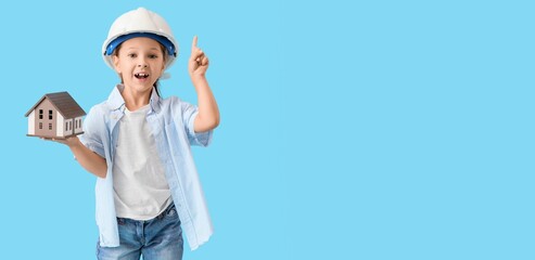 Cute little architect with house model on light blue background with space for text