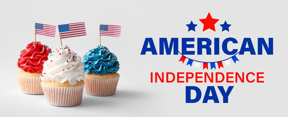 Tasty patriotic cupcakes with USA flags on grey background. American Independence Day