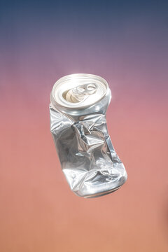 Crushed aluminum can on gradient background
