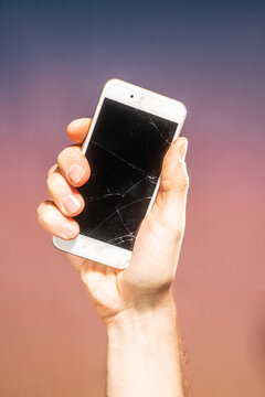 Hand holding cracked smartphone
