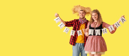 Happy young couple with garland on yellow background with space for text. Banner for Festa Junina (June Festival)
