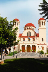 The stunning architecture of a magnificent Greek church featuring a beautiful bell tower set against a cloudy sky. Rethymno town, Crete island, Greece.