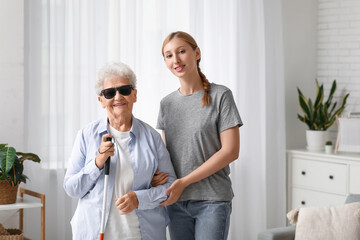 Fototapeta premium Young woman with blind grandmother at home