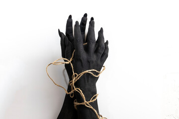 Concept photo with woman hands painted in black paint with a rope wrapping her hands